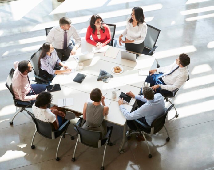 Businesswoman addressing meeting, elevated view, vertical