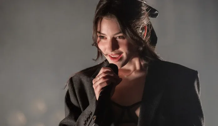 Singer Gracie Abrams holding a microphone during a live performance