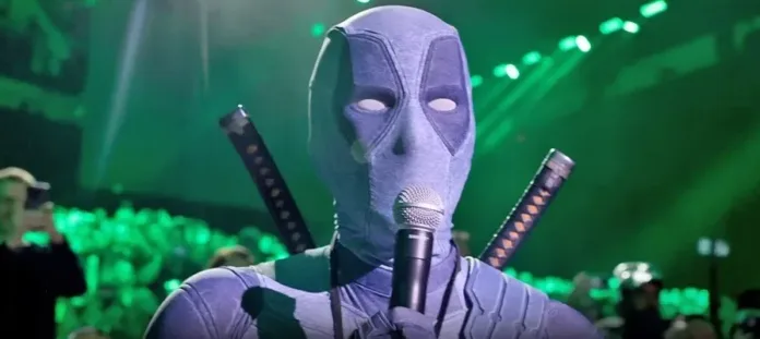 Ryan Reynolds in a Deadpool costume speaks into a microphone during the Deadpool Comic-Con stunt at Marvel's San Diego Comic-Con panel