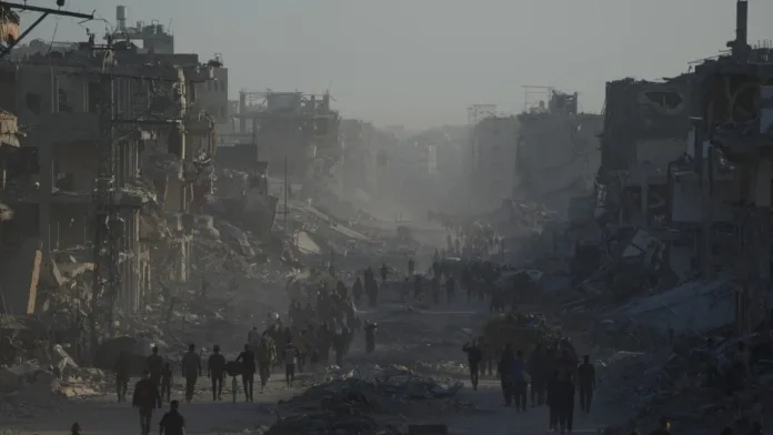 Damaged buildings and civilians walking through a devastated street in Gaza amid discussions over the Hamas disarmament deal.