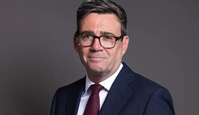 Official portrait of Andy Burnham wearing a suit and glasses