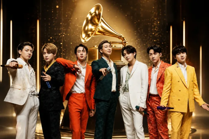 BTS pose in colorful suits beneath a golden gramophone trophy, illustrating the reported BTS Grammy boycott.