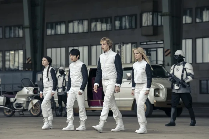 Four District 12 tributes, including Joseph Zada as Haymitch Abernathy, walk towards the launch room in The Hunger Games: Sunrise on the Reaping.
